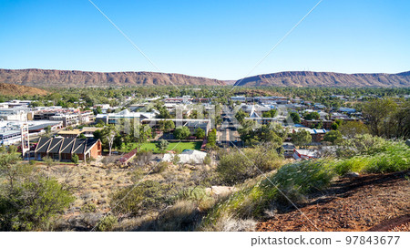 The town of Alice Springs and the rocky mountains behind it 97843677