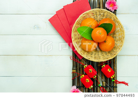 Chinese language mean rich or wealthy and happy.Top view aerial image decoration Chinese new year lunar new year holiday background concept.Flat lay red orange with blossom on modern white table. Chinese language mean rich or wealthy and happy.Top view aerial image decoration Chinese new year lunar new year holiday background concept.Flat lay red orange with blossom on modern white table. 97844493