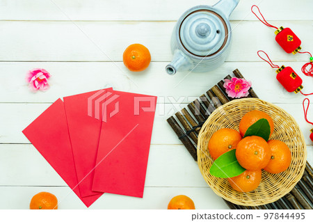 Chinese language mean rich or wealthy and happy.Top view aerial image decoration Chinese new year lunar new year holiday background concept.Flat lay red orange with blossom on modern white table. Chinese language mean rich or wealthy and happy.Top view aerial image decoration Chinese new year lunar new year holiday background concept.Flat lay red orange with blossom on modern white table. 97844495