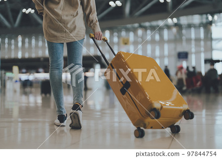 International airport terminal. Asian beautiful woman with luggage and walking in airport International airport terminal. Asian beautiful woman with luggage and walking in airport 97844754