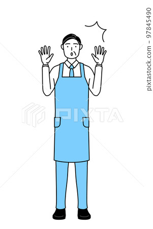 A senior man wearing an apron raising his hand in surprise A senior man wearing an apron raising his hand in surprise 97845490