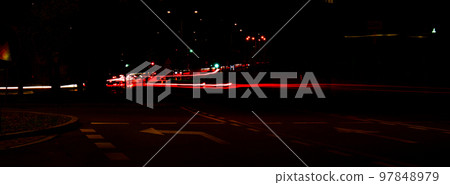 Lights of cars at night. Street line lights. Night highway city. Long exposure photograph night road. Colored bands of red light trails on the road. Background wallpaper defocused blurred Banner size Lights of cars at night. Street line lights. Night highway city. Long exposure photograph night road. Colored bands of red light trails on the road. Background wallpaper defocused blurred Banner size 97848979