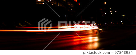 Lights of cars at night. Street line lights. Night highway city. Long exposure photograph night road. Colored bands of red light trails on the road. Background wallpaper defocused blurred Banner size Lights of cars at night. Street line lights. Night highway city. Long exposure photograph night road. Colored bands of red light trails on the road. Background wallpaper defocused blurred Banner size 97848984
