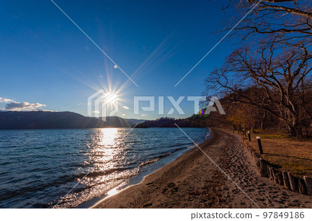 春天在青森縣十和田湖看到的湖岸景色被太陽和接近黃昏的藍天照亮 97849186