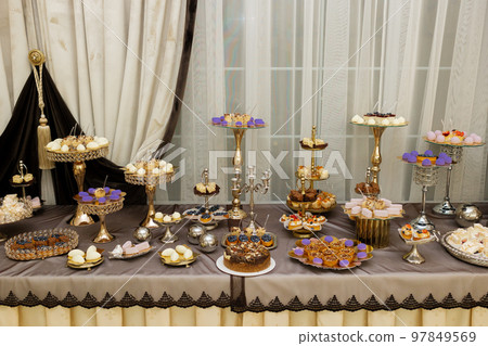 Table with cakes, sweets, candy, buffet. Dessert table for a party goodies for the wedding banquet area. Close up candy bar. Decorated delicious. 97849569