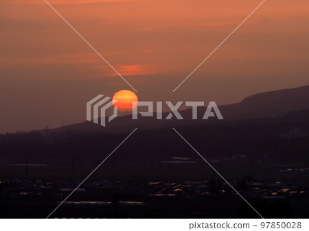 萬代山腳下的夕陽。鮮紅的太陽、橙色的天空和山的輪廓之間的對比很美。 97850028