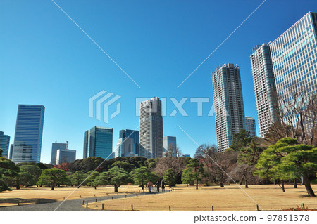 公園裡有許多樹木,周圍環繞著建築物 公園裡有許多樹木,周圍環繞著建築物 97851378