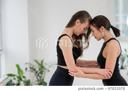 Caucasian woman stands on sadhu boards with therapist support. Caucasian woman stands on sadhu boards with therapist support. 97852078