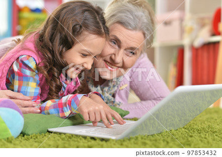 grandmother and daughter using modern laptop at home 97853432