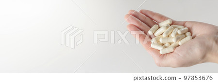 Probiotics. Preparation for restoration of intestinal microflora. Handful of white capsules with probiotic powder inside. The concept of health care and recovery of health after taking antibiotics Probiotics. Preparation for restoration of intestinal microflora. Handful of white capsules with probiotic powder inside. The concept of health care and recovery of health after taking antibiotics 97853676