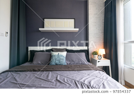 Warm and cozy interior of bedding room space with bed, mock up poster frame. Cozy home decor. 97854337