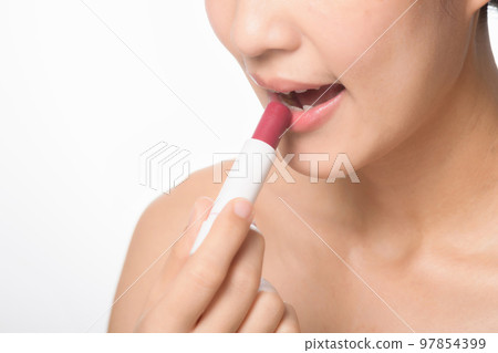 Beautiful portrait young asian woman looking mirror applying makeup lipstick at room. clipping path 97854399