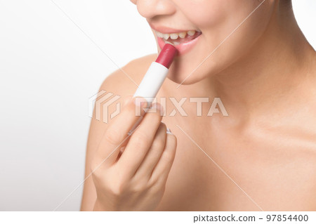 Beautiful portrait young asian woman looking mirror applying makeup lipstick at room. clipping path 97854400