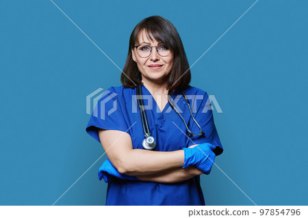 Portrait of nurse doctor woman looking at camera on blue background Portrait of nurse doctor woman looking at camera on blue background 97854796