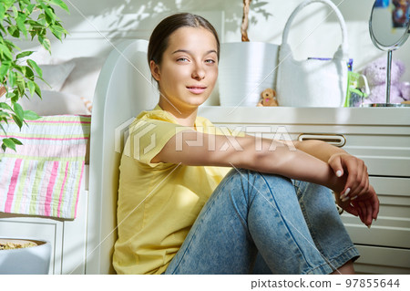 Beautiful teenage girl sitting at home on floor, in sunlight Beautiful teenage girl sitting at home on floor, in sunlight 97855644