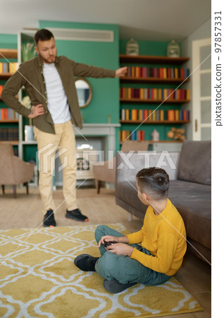 Parent scolding child addicted to modern technologies at home Parent scolding child addicted to modern technologies at home 97857331