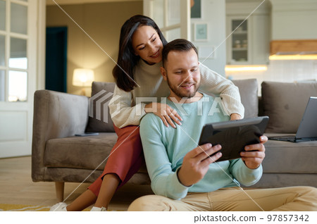 Happy young family couple using mobile tablet at home together 97857342