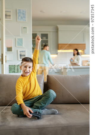 A boy playing video computer game at home living room A boy playing video computer game at home living room 97857345