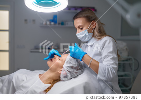 Anti-aging treatment and filler injection between eyebrow concept Anti-aging treatment and filler injection between eyebrow concept 97857383