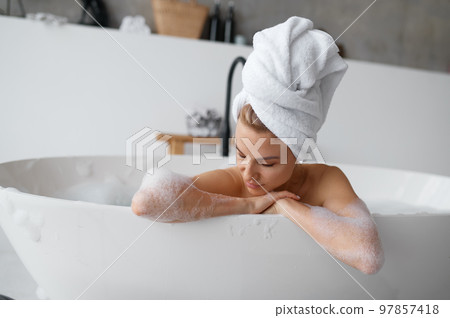 Portrait of gorgeous woman in towel on head taking bath 97857418
