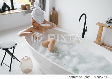 Portrait of gorgeous woman in towel on head taking bath 97857419