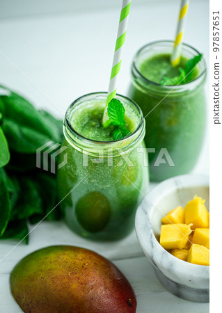 Top view of green smoothie with mango, spinach on wooden table. Healthy food. Vegetarian diet 97857651