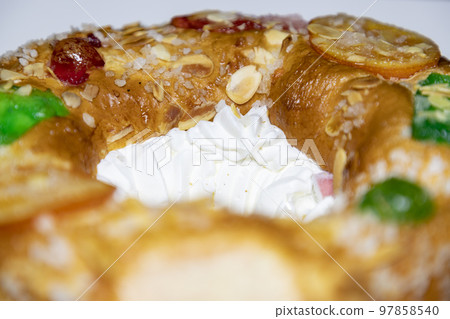 Roscon. Roscon de Reyes. Kingcake. Bun made with a sweet dough in the shape of a toroid decorated with slices of candied, candied or crystallized fruit of various colors with cream inside. Roscon. Roscon de Reyes. Kingcake. Bun made with a sweet dough in the shape of a toroid decorated with slices of candied, candied or crystallized fruit of various colors with cream inside. 97858540