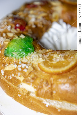 Roscon. Roscon de Reyes. Kingcake. Bun made with a sweet dough in the shape of a toroid decorated with slices of candied, candied or crystallized fruit of various colors with cream inside. Roscon. Roscon de Reyes. Kingcake. Bun made with a sweet dough in the shape of a toroid decorated with slices of candied, candied or crystallized fruit of various colors with cream inside. 97858541