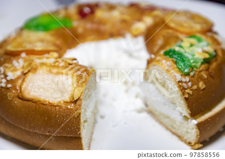 Roscon. Roscon de Reyes. Kingcake. Bun made with a sweet dough in the shape of a toroid decorated with slices of candied, candied or crystallized fruit of various colors with cream inside. 97858556