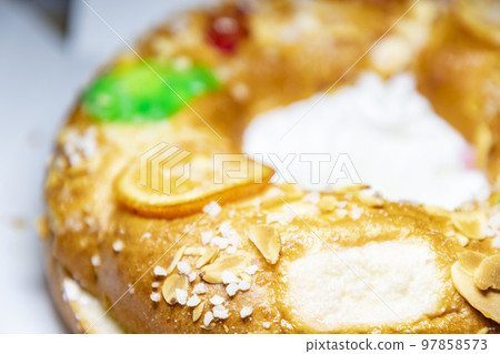 Roscon. Roscon de Reyes. Kingcake. Bun made with a sweet dough in the shape of a toroid decorated with slices of candied, candied or crystallized fruit of various colors with cream inside. Roscon. Roscon de Reyes. Kingcake. Bun made with a sweet dough in the shape of a toroid decorated with slices of candied, candied or crystallized fruit of various colors with cream inside. 97858573