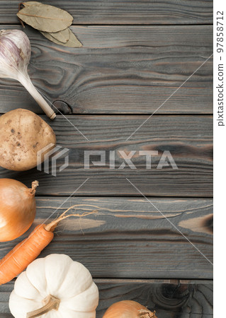 Mix of flavorings and vegetables. Layout of foodstuffs on kitchen wooden table. Planking, place for text, flat lay. 97858712