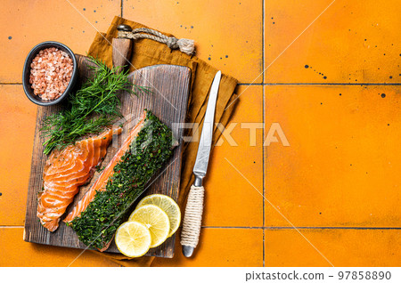 Scandinavian Gravlax Salmon fillet with dill, salt and papper. Orange background. Top view. Copy space 97858890