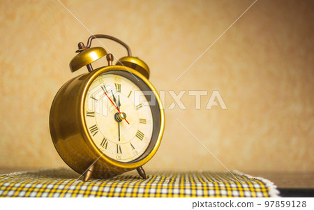 Retro alarm clock with five minutes to twelve o'clock. Old style filtered photo Retro alarm clock with five minutes to twelve o'clock. Old style filtered photo 97859128