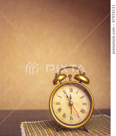 Retro alarm clock with five minutes to twelve o'clock. Old style filtered photo 97859131