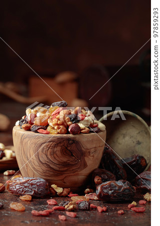 Dried fruits and nuts in a wooden bowl. 97859293