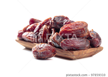 Dates in a wooden dish isolated on a white background. 97859310