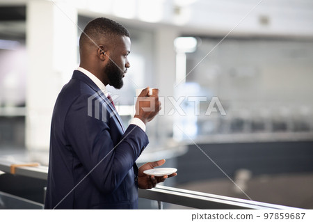 Rear view of young black manager drinking coffee 97859687