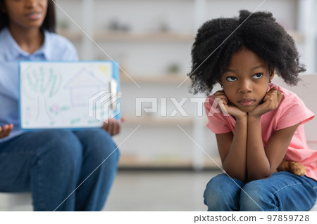 Bored little girl avoiding unrecognizable child psychologist 97859728