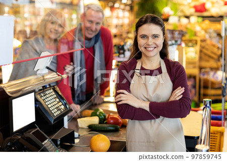 Portrait of beautiful young woman cashier smiling at camera Portrait of beautiful young woman cashier smiling at camera 97859745