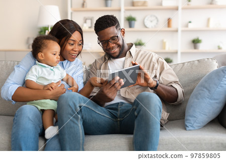 Portrait of black family using digital tablet at home 97859805