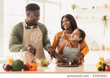 African Parents And Daughter Making Salad Together Cooking In Kitchen African Parents And Daughter Making Salad Together Cooking In Kitchen 97859882
