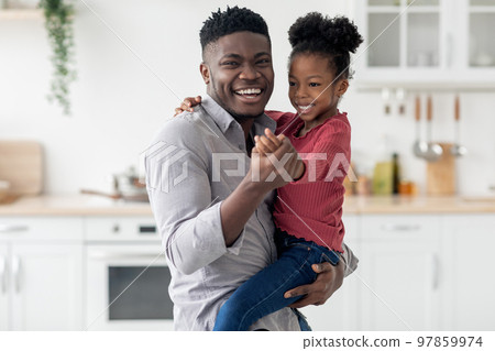 Happy black father holding his cute little daughter Happy black father holding his cute little daughter 97859974