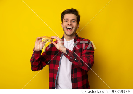 Funny Young Guy Holding Burger At Studio Funny Young Guy Holding Burger At Studio 97859989