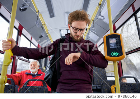 Portrait of ginger curly haired wearing glasses and wrist watch in aubergine sweater male rushing trying to fasten with urban transport. Hasty rythm of life people make too many plans getting nervous Portrait of ginger curly haired wearing glasses and wrist watch in aubergine sweater male rushing trying to fasten with urban transport. Hasty rythm of life people make too many plans getting nervous 97860146