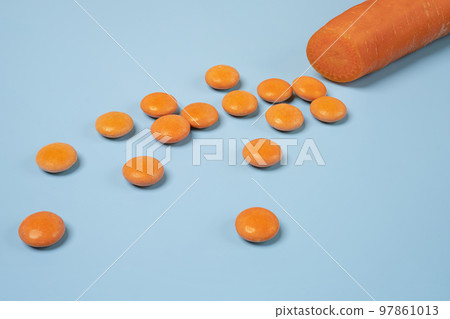Orange vitamin D pills and a carrot Orange vitamin D pills and a carrot 97861013