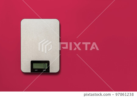 Digital kitchen scales against viva magenta background. 97861238