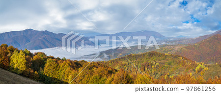 Foggy early morning autumn mountains scene. Peaceful picturesque traveling, seasonal, nature and countryside beauty concept scene. Carpathian Mountains, Ukraine. 97861256
