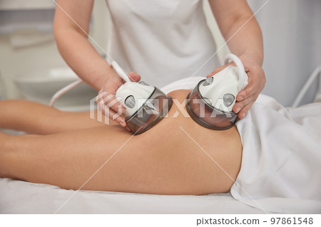 ultrasonic action, receiving massage, Slimming vacuum. Anti-cellulite roller vacuum massage takes place in medicine salon. Slim problem areas, special body care professional equipment, perform lpg 97861548