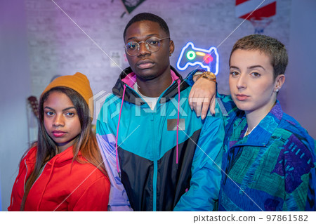 Multiethnic teenager friends taking photo with unfiltered flash. Night life photo shooting indoor. 97861582
