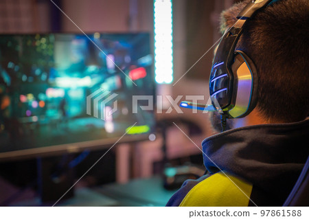 Rear view of young guy wear headphones play videogame weekend sports hobby indoors 97861588